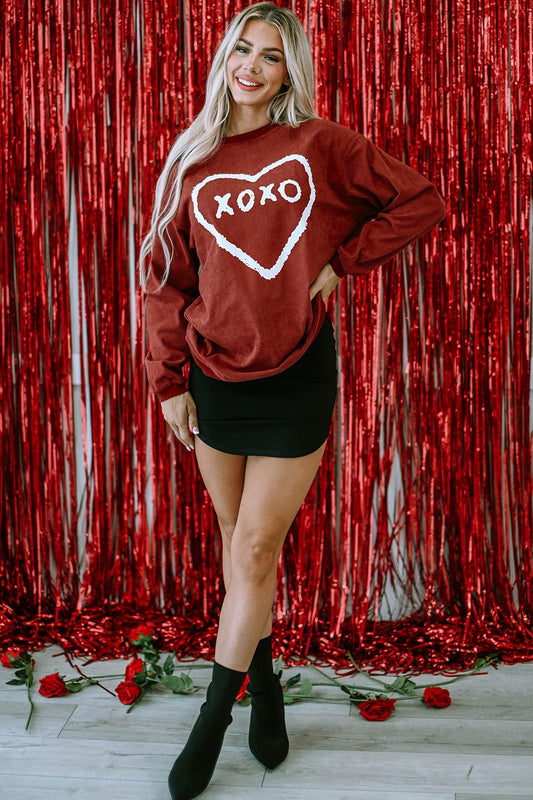 xoxo with heart sweatshirt in red. valentines day outfit inspo red sweatshirt, black skirt, black boots