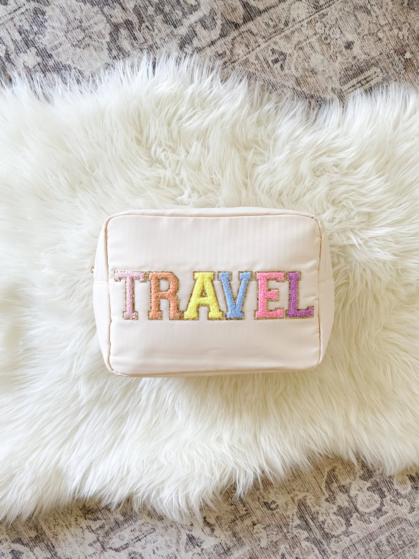 extra large embroidered bag in beige with rainbow chenille patches saying "travel"