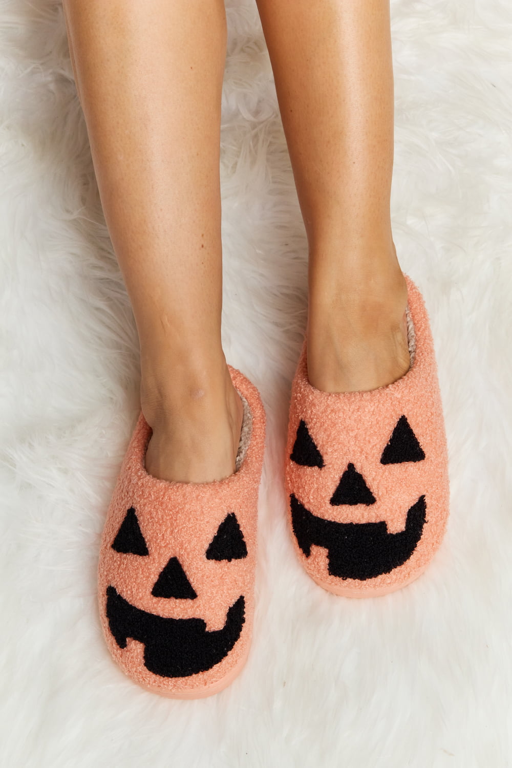 cozy pumpkin face slippers in orange