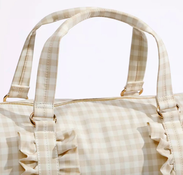 closeup of handles on gingham ruffle duffle bag